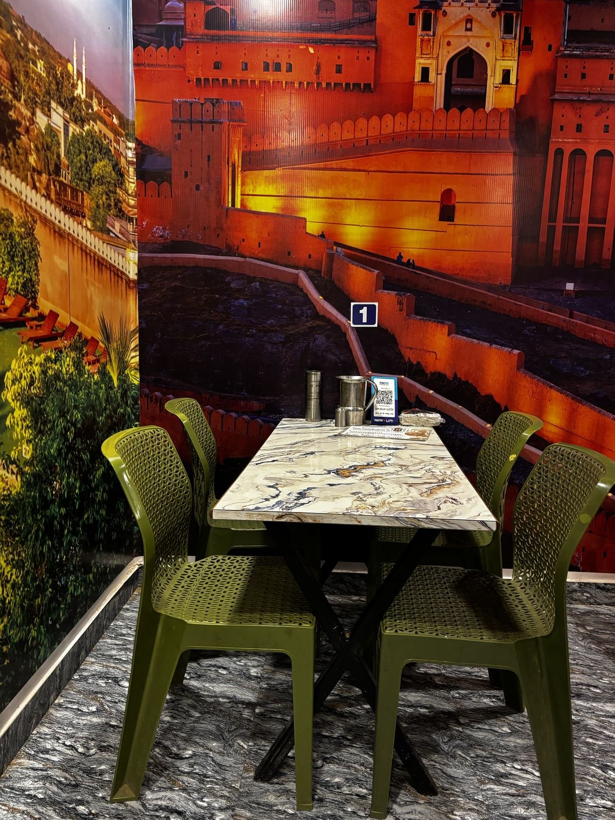 Dining seating at Seth Sawariya Hotel and Restaurant with Rajasthani fort mural